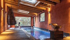A spa area with a wooden deck, a pool, and a large window offering a view of trees. - Villa Hippocampe (Six-Fours-les-Plages)