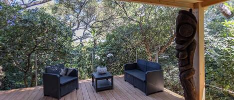 Una terrazza esterna con mobili in vimini e una scultura decorativa in pietra.