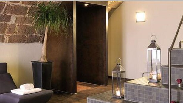 A spa area with a massage chair, a potted plant, a tiled bench, and a lantern. - Schlosshotel Bergzaberner Hof (Bad Bergzabern)