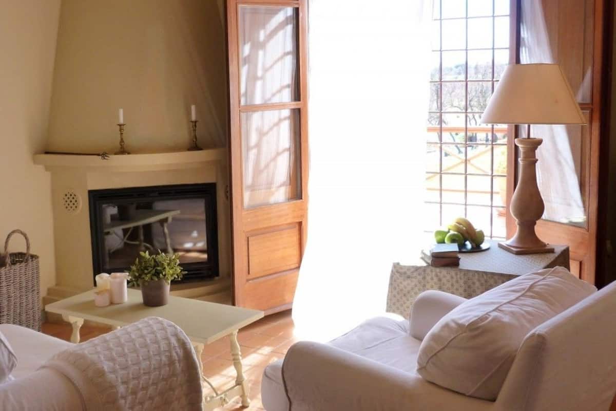 Een gezellige woonkamer met een open haard, comfortabele zitplaatsen en een tafel met lamp.