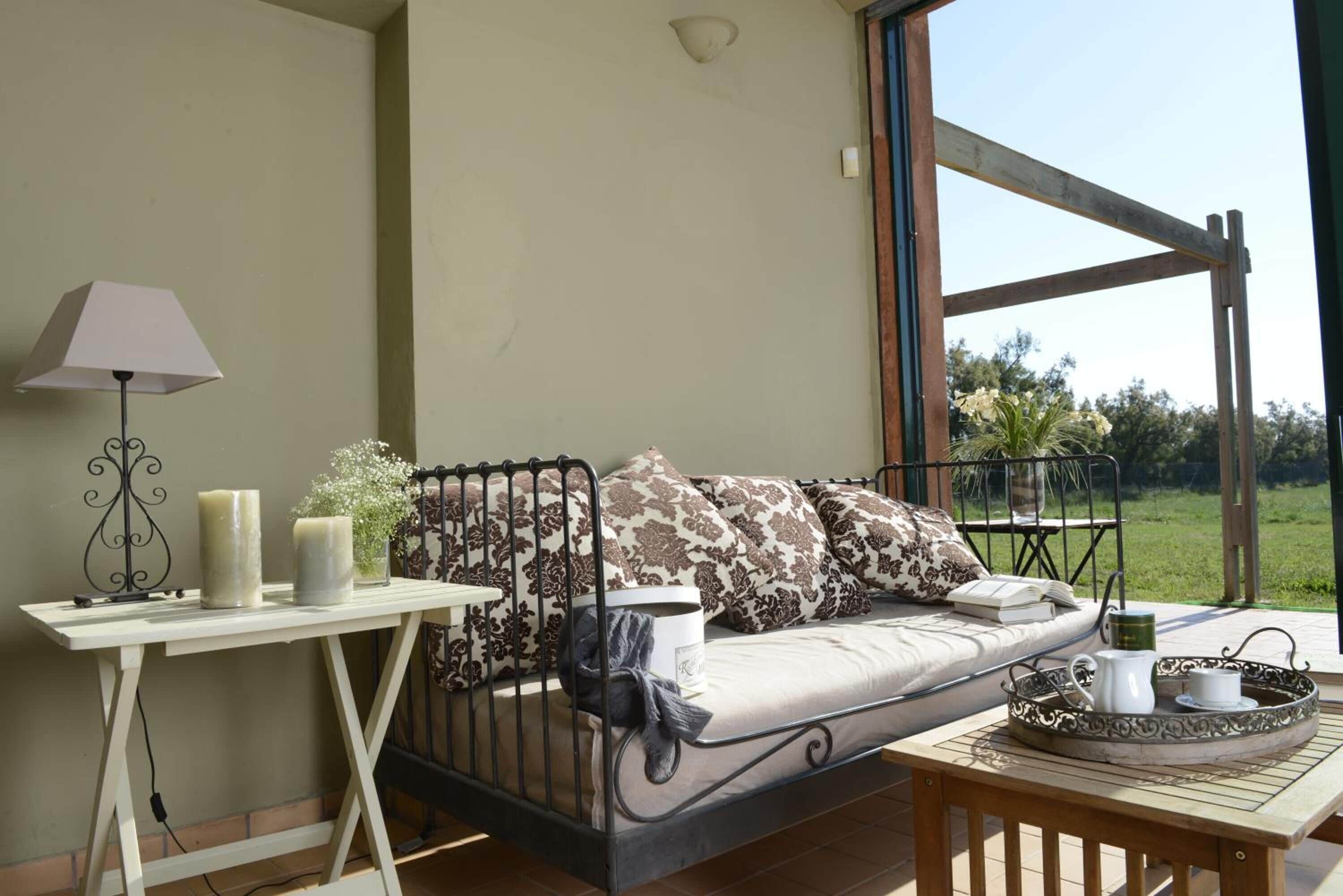Un espacio al aire libre acogedor con un sofá, una mesa con bandeja y una lámpara.