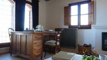 Une pièce avec un bureau en bois, une chaise, un radiateur et une cheminée.