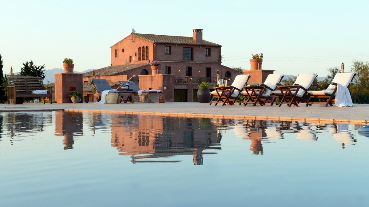 Een seizoensgebonden buitenzwembad en ligstoelen