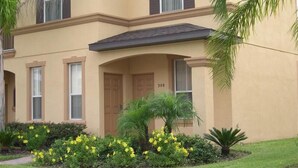 A two-story building with a beige facade, a dark roof, and a number '308' on the front door. There are three windows on the ground floor and two on the upper floor. - Regal Palms Spa & Resort (Davenport)