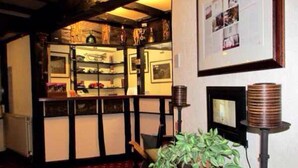 A room with a red carpet, a bookshelf, a framed picture on the wall, and a potted plant. - The Sunningdale (Skegness)