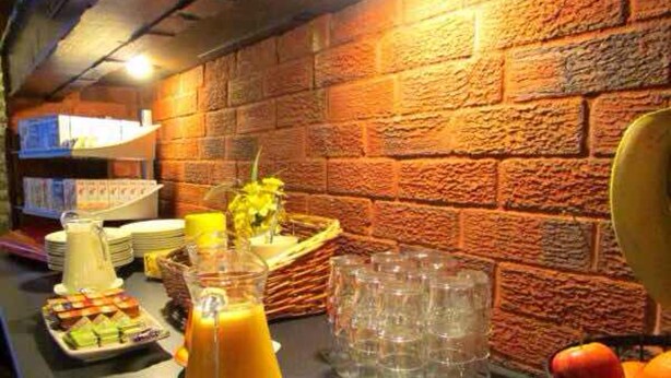 A breakfast buffet with various food items, a pitcher of orange juice, and a fruit bowl. - The Sunningdale (Skegness)