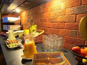 A breakfast buffet with various food items, a pitcher of orange juice, and a fruit bowl. - The Sunningdale (Skegness)