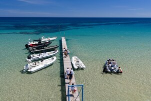 Un muelle con barcos amarrados y gente caminando.