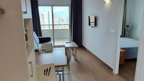 Um apartamento moderno com área de jantar, cozinha e varanda com vista para a cidade.