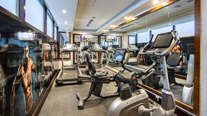 Een fitnessruimte met loopbanden, elliptische trainers en krachttrainingsapparaten.