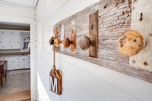 A rustic wall with a wooden plank and metal fixtures, including a door with a round knob and a keyhole.