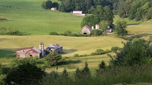 Paisagem rural com celeiros, campos e árvores.