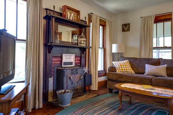 A cozy living room with a fireplace, a sofa, a coffee table, and a television.