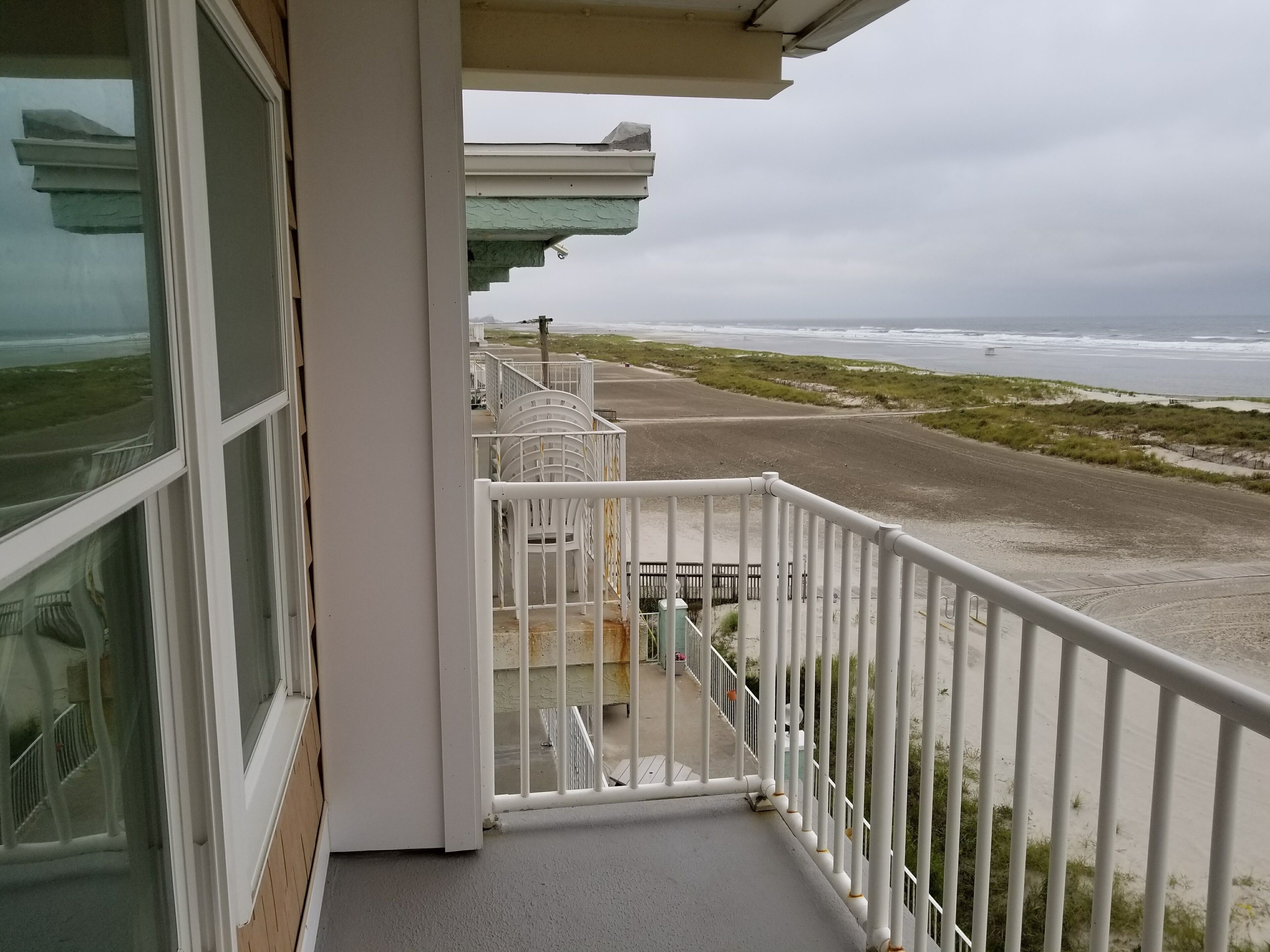 Un balcon avec vue sur la plage et l’océan.