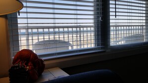 A room with a window overlooking a beach, a lamp, and a stuffed toy on the windowsill. - Welcome to "Ocean Sunrise". Renovated direct ocean front private end unit.  (Wildwood Crest)