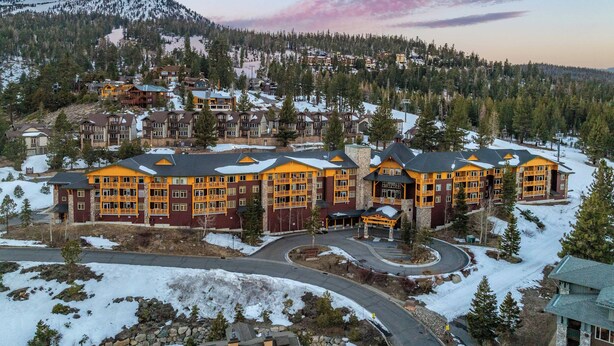 A large lodge with multiple buildings, surrounded by snow-covered ground and trees, with a mountain in the background. - Ski In-Ski Out Exclusive Lift Access Resort Condo at Mammoth Mountain Lakes CA (Mammoth Lakes)