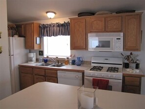 Kitchen features a microwave, stove, dishwasher, and sink with a faucet.