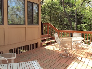 Enjoy dining or socializing on the deck with comfortable seating and a small table.