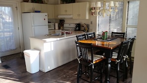 Enjoy meals in the kitchen and dining area, featuring a central island with a sink and microwave, a refrigerator, and a dining table with six chairs.