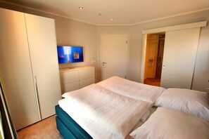 A bedroom with a bed, a TV, and a wardrobe.