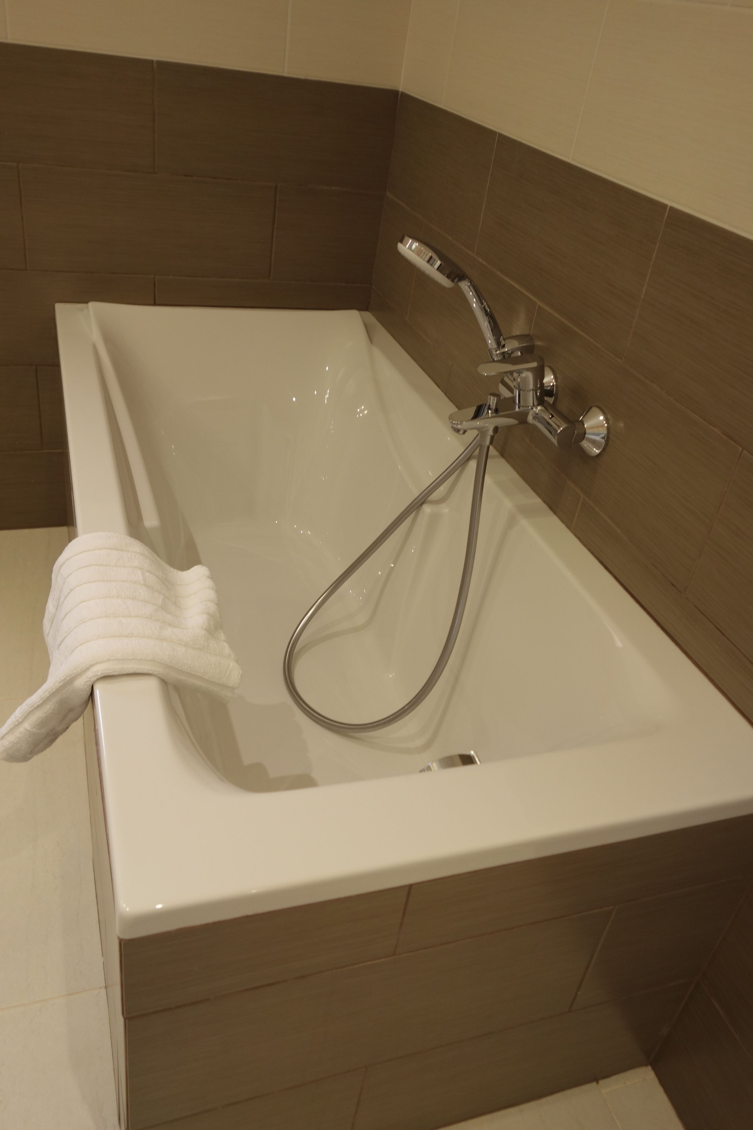 Una bañera con ducha y una toalla.