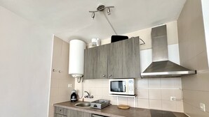 A compact kitchen with a built-in microwave, a coffee maker, and a dishwasher.