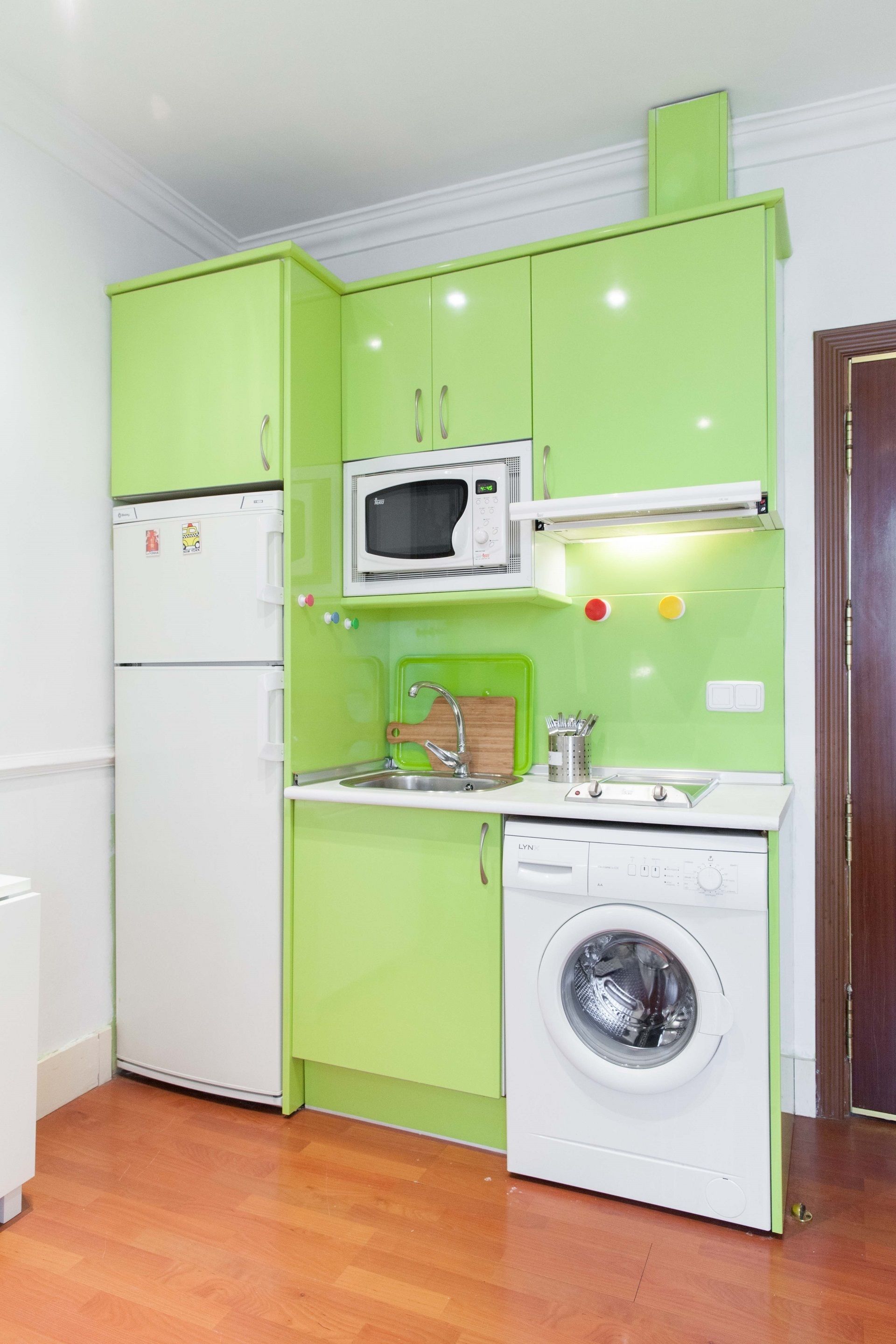 Cocina compacta con microondas, lavaplatos y lavadora.