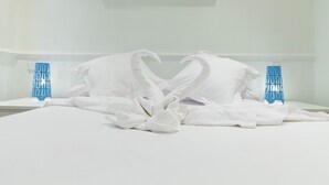 A neatly made bed with white linens and two decorative pillows shaped like swans. - Glorieta de Bilbao Madrid Centro (Madrid)