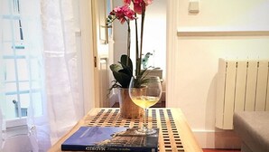 A wooden table with a book and a vase of pink flowers. - Glorieta de Bilbao Madrid Centro (Madrid)