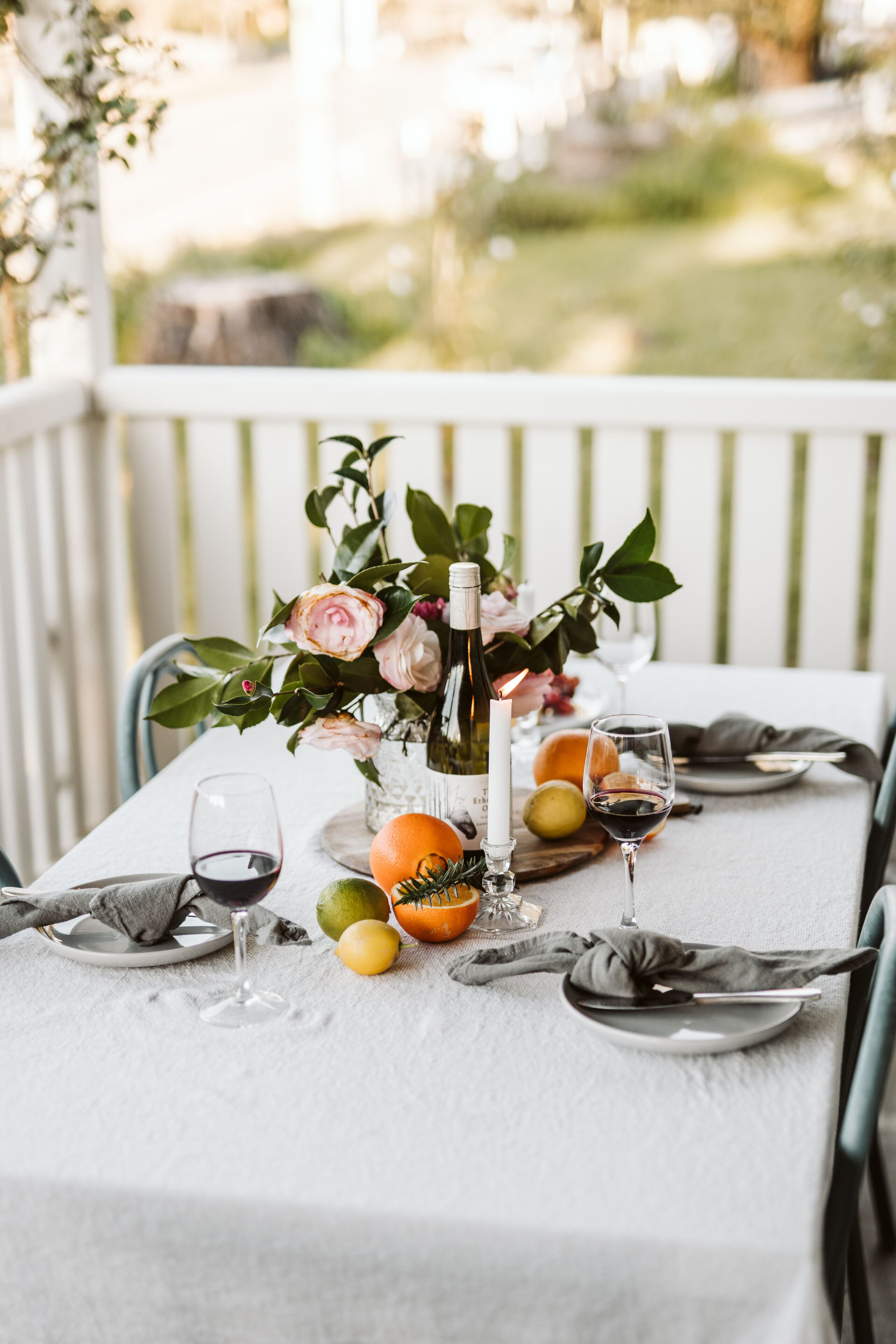 Ein gedeckter Tisch mit Blumen, Weingläsern und Früchten.