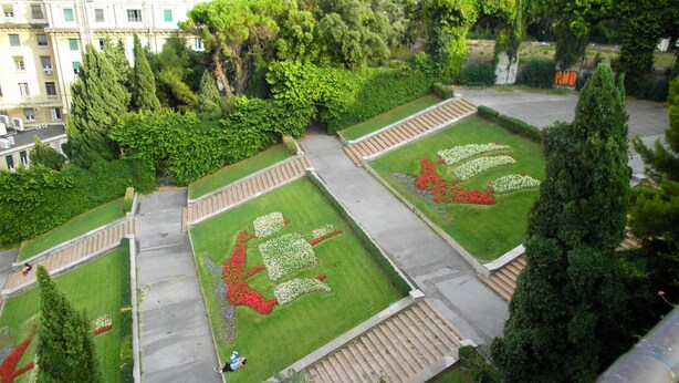 A landscaped garden with geometric patterns, pathways, and a central staircase.