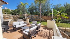 An outdoor patio with a stone wall, a stone staircase, and a variety of seating arrangements including sofas and chairs. - Very nice house fully equipped, wonderful terrace with garden, garage (VILAMOURA)
