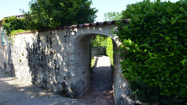 A stone archway leading to a gravel path. - Sunny holiday in the quiet countryside with pool. (Lalbenque)