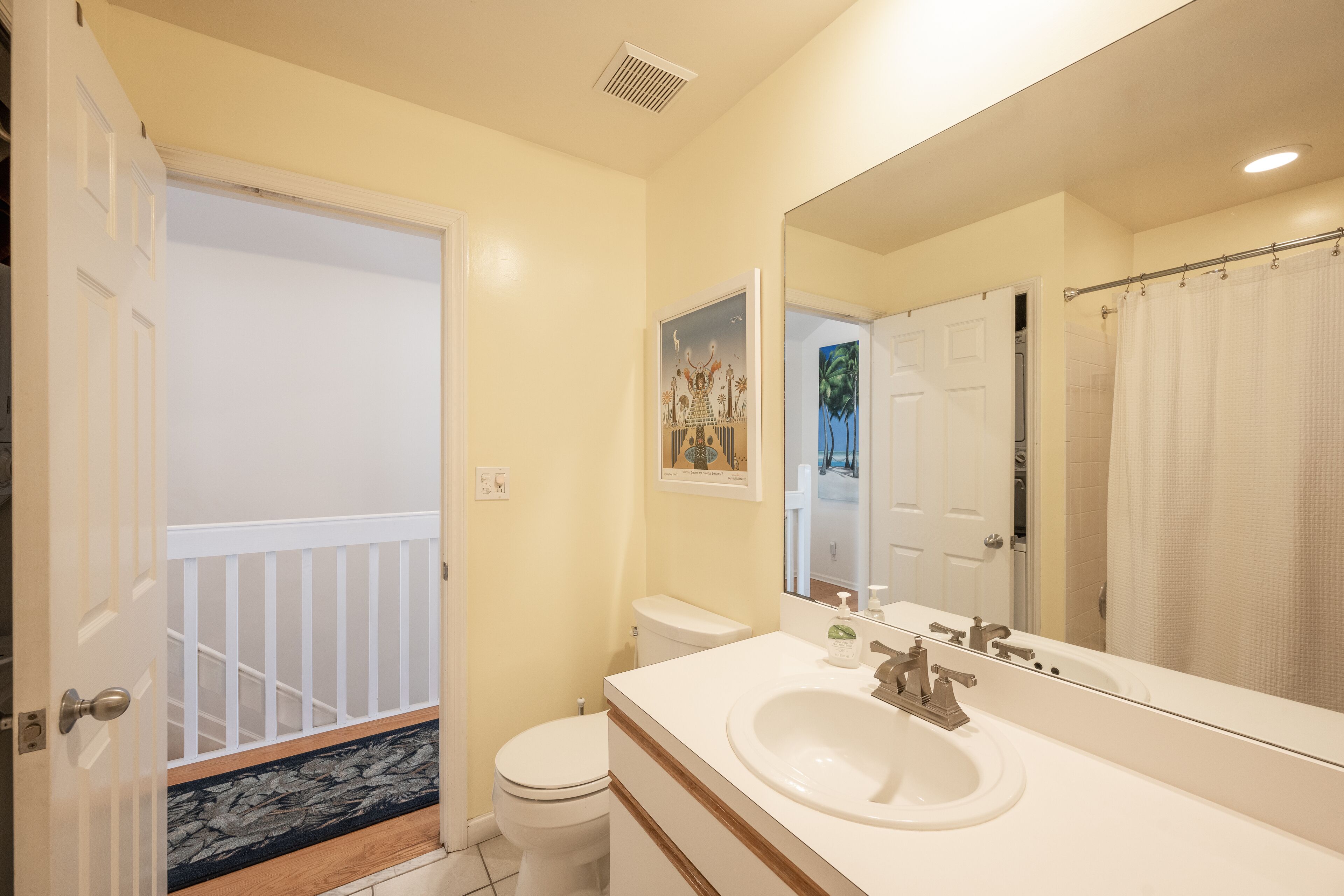A bathroom with a toilet, sink, and shower curtain.