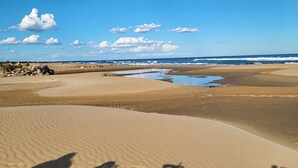 A beach with sand dunes and a clear sky.