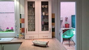 A kitchen with a wooden countertop, a wicker basket, and a cabinet with glass doors.