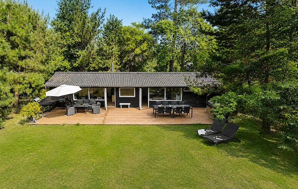 A modern house with a patio, outdoor furniture, and a large umbrella. - 3 bedroom stunning home in Vig (Vig)