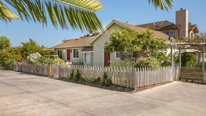 A residential house with a fenced backyard, a patio area, and a garage.
