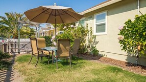 A patio with a table and chairs, an umbrella, and a house number 232.