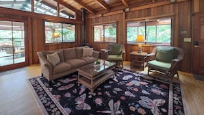 A wooden interior with a sofa, chairs, a table, and a ceiling fan. - Hale Mauna Loa Volcano Vacation Getaway-Upper Level Volcanoes National Park  (Volcano)