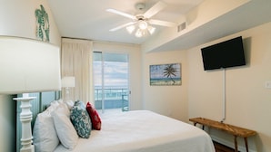 A bedroom with a bed, a ceiling fan, a TV, a window with curtains, and a balcony. - Silver Beach 103 | Updated, Direct Beach Front, Pet Friendly! (Orange Beach)