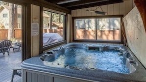 Ein Whirlpool in einer Außenanlage mit Holzterrasse und überdachtem Bereich.