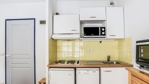 A compact kitchen with white cabinets, a microwave, a dishwasher, and a stove. - Apartment Cauterets, 1 bedroom, 4 persons (Cauterets)