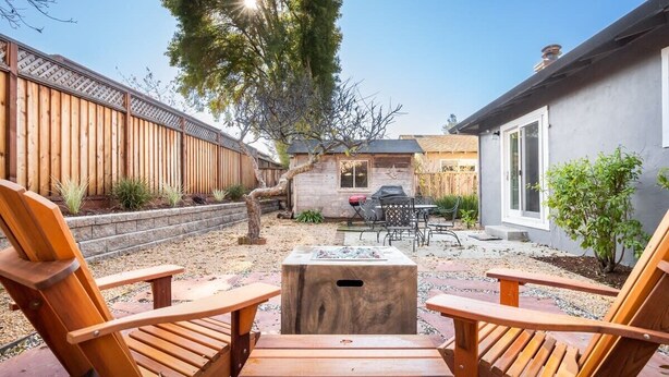 Ein Garten mit einer Holterrasse, einem Grill und einem kleinen Tisch.