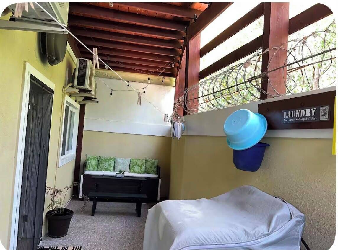 Un espace dédié à la lessive, comprenant un banc, un lit à baldaquin et un panier à linge fixé au mur.