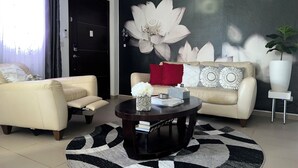 Ein modernes Wohnzimmer mit zwei Sofas, einem Couchtisch und einem großen floralen Wandbild.