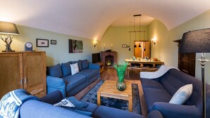 Ein gemütliches Wohnzimmer mit Kamin, Sofas und einem Essbereich.