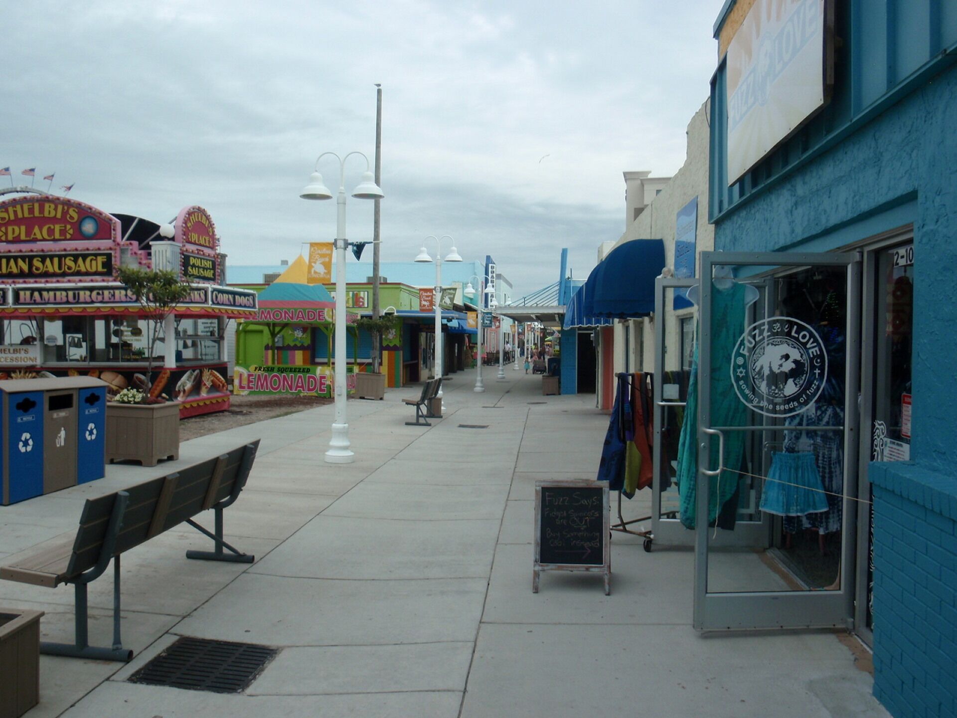 A boardwalk with various shops, including a bakery and a clothing store.