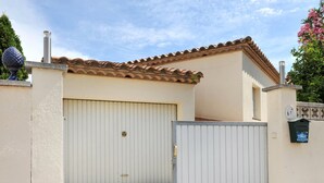 A gated entrance to a building with a tiled patio area.