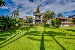 A two-story house with a large front lawn, a balcony, and a pool area. - RARE, GATED, PRIVATE BEACHFRONT HOME! PRIVATE POOL, 6 BEDS 6 BATHS (Kihei)